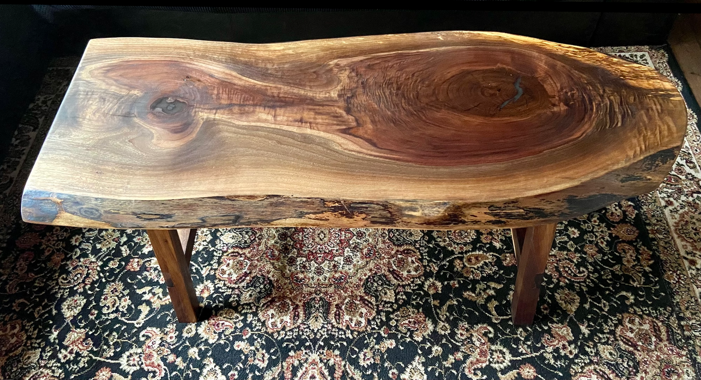 Ultra unique oval rustic natural live edge black walnut coffee table offers natural walnut wood with gorgeous grain patterns, complete with a large knot, a smaller knot, radial grain dancing around the entire table, completed with curl and a long oval shape.